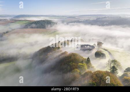 Luftaufnahme durch Drohne des Herbstnebels, der über Restormel Castle in Cornwall, Großbritannien, Europa wirbelt Stockfoto