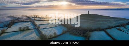 Luftbild bei einer Drohne von frostigen Winteraufgängen über Glastonbury Tor, Somerset, England, Großbritannien, Europa Stockfoto