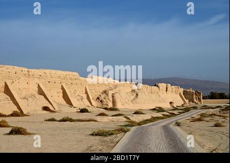 Straße vorbei an der zerstörten Stadtmauer der alten Seidenstraßenstadt Gaochang, Taklamakan-Wüste, Xinjiang, China, Asien Stockfoto