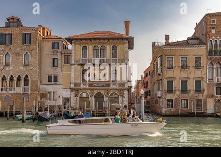 Ein Wassertaxi mit Passagieren fährt am Palazzo Salviati vorbei, einem Palast, der 1924 am Canale Grande im Stadtteil Dorsoduro in Venedig, Italien, erbaut wurde Stockfoto