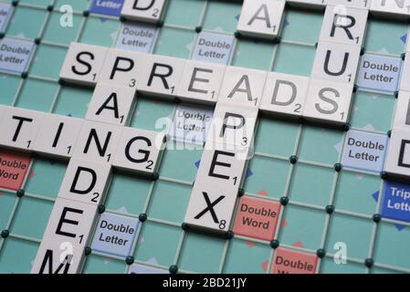 Coronavirus verwandte Wörter, die auf einem Scrabble Board ausgeschrieben sind. Konzeptbild für redaktionelle Kovid-19-bezogene Geschichten. Mit selektivem Fokus. Stockfoto