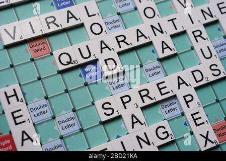 Coronavirus verwandte Wörter, die auf einem Scrabble Board ausgeschrieben sind. Konzeptbild für redaktionelle Kovid-19-bezogene Geschichten. Mit selektivem Fokus. Stockfoto