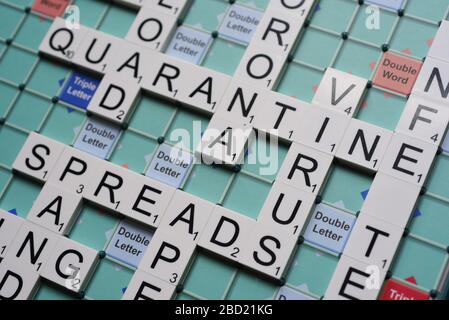 Coronavirus verwandte Wörter, die auf einem Scrabble Board ausgeschrieben sind. Konzeptbild für redaktionelle Kovid-19-bezogene Geschichten. Mit selektivem Fokus. Stockfoto