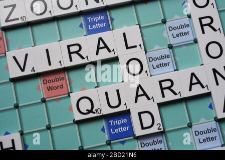 Coronavirus verwandte Wörter, die auf einem Scrabble Board ausgeschrieben sind. Konzeptbild für redaktionelle Kovid-19-bezogene Geschichten. Mit selektivem Fokus. Stockfoto