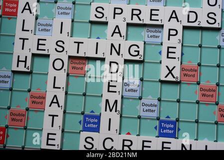 Coronavirus verwandte Wörter, die auf einem Scrabble Board ausgeschrieben sind. Konzeptbild für redaktionelle Kovid-19-bezogene Geschichten. Mit selektivem Fokus. Stockfoto