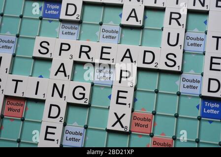 Coronavirus verwandte Wörter, die auf einem Scrabble Board ausgeschrieben sind. Konzeptbild für redaktionelle Kovid-19-bezogene Geschichten. Mit selektivem Fokus. Stockfoto