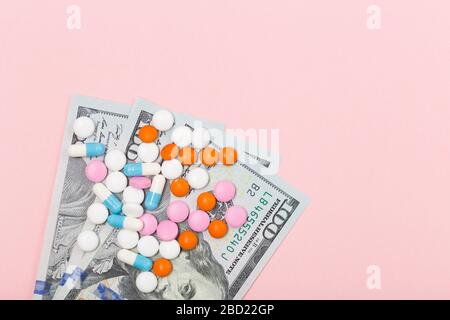 Medikamente, Tabletten und Spritze auf US-Dollar auf pinkfarbenem Hintergrund. Konzept für das Gesundheitswesen. Krise. Geld. Freier Speicherplatz. Kopierbereich. Stockfoto