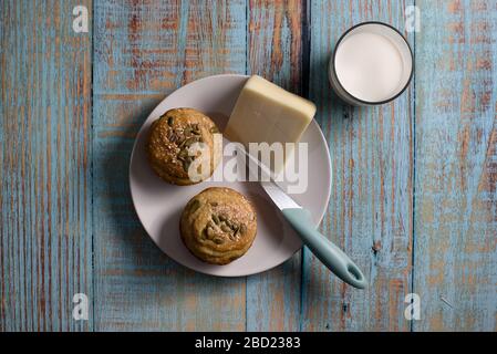 Maisbrot in Form von Muffins ( proa ) mit Sesam und Kürbissamen mit Käse und Glas Joghurt. Balkanküche. Blaues rustikales Holz Stockfoto