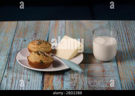 Maisbrot in Form von Muffins ( proa ) mit Sesam und Kürbissamen mit Käse und Glas Joghurt. Balkanküche. Blaues rustikales Holz Stockfoto