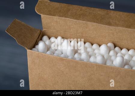 Nahaufnahme von Bambusstäbchen in der Öko-Papierbox auf blauem Hintergrund. Umweltfreundliches und schutstofffreie Konzept. Selektiver Fokus Stockfoto