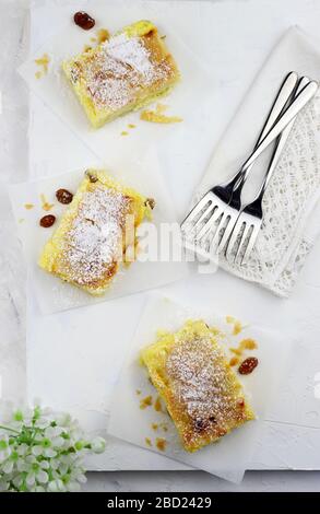 Stücke hausgemachtes traditionelles griechisches Gebäck - Bougatsa-Gebäck aus Phyllo-Teig und mit Zuckerpulver bestreuter Grießkeim. Draufsicht. Stockfoto