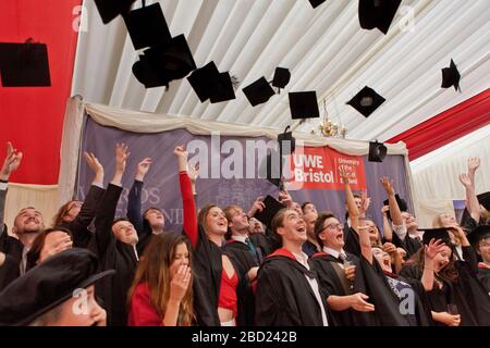 Studenten feiern den Abschluss, indem sie ihre Mörtelbretter in die Luft werfen Stockfoto