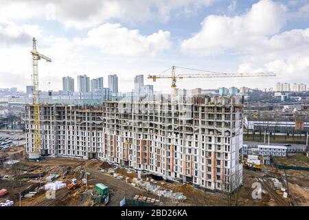 Stadtbaustelle mit gelben Turmkränen und Maschinen. Luftbild Draufsicht auf Wohnbaugebiet. Stockfoto