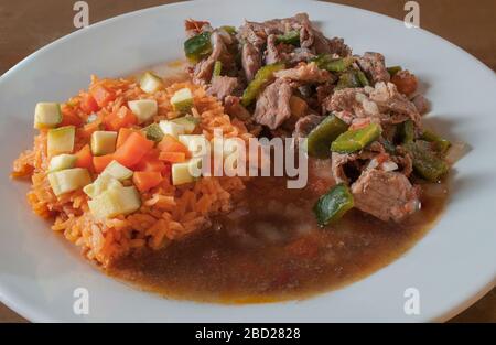 Mexikanisches Rinder-Ranchero-Steak mit chile und mexikanischem Reis auf der Seite mit Gemüse auf dem Reis würzigen Gericht Ranch-Rind-Steak Stockfoto