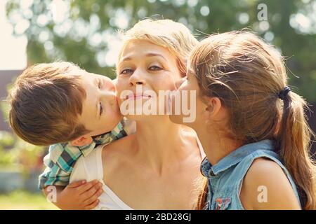 Porträt einer glücklichen Familie im Freien. Mama mit Kindern im Sommer. Mutter und Kinder. Stockfoto