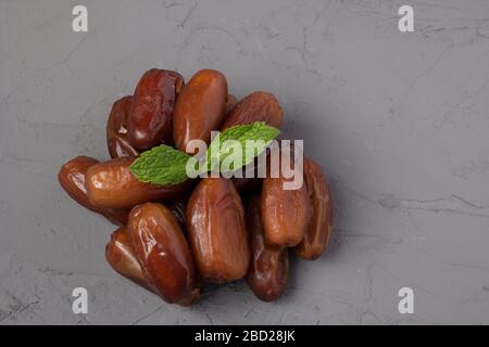 Datumfrucht Medjool auf grauem Hintergrund getrocknet, flach gelegt und kopiert Stockfoto