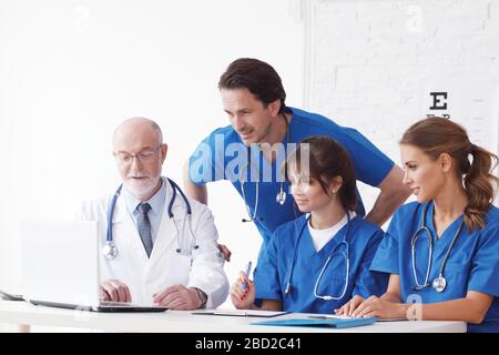 Ärzteteam bei Rücksprache im klinischen Büro mit Laptop Stockfoto