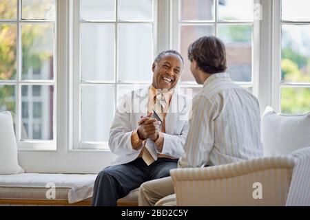 Beratung eines Oberarztes mit einem Patienten mittleren Alters. Stockfoto