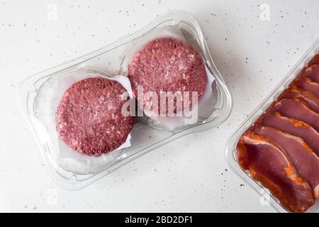 Verschiedene Fleischsorten, die in Kunststoff auf Holztisch verpackt sind Stockfoto