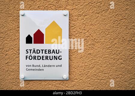 Schild an einem renovierten Gebäude mit der Aufschrift Stadtentwicklung. Die Sanierung dieses Hauses wurde durch Zuschüsse finanziert. Stockfoto