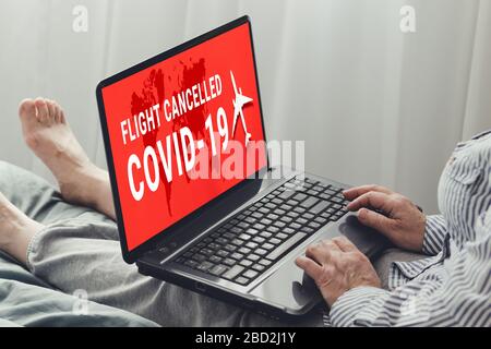 Coronavirus, Kovid-19 Breaking News. Eine Frau schaut sich die Neuigkeiten auf einem Laptop an, während sie auf einem Sofa in einem Haus sitzt. Bleiben Sie in Quarantäne Stockfoto