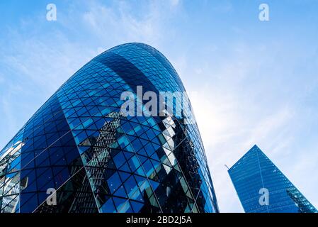 London, Großbritannien - 14. Mai 2019: Niedriger Blickwinkel auf Bürogebäude in der City of London gegen blauen Himmel. 30 St. Mary Ax oder Gherkin bei Norman Fost Stockfoto