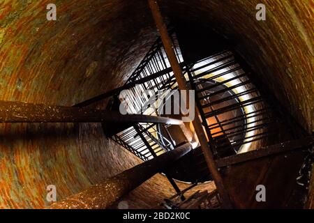 Rostiger Wasserturm von oben nach unten von innen. Alte Wasserpumpe. Leiter zum Wassertank, Taubenkot. Stockfoto