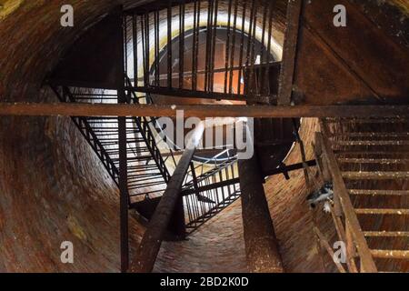 Rostiger Wasserturm von oben nach unten von innen. Alte Wasserpumpe. Leiter zum Wassertank, Taubenkot. Stockfoto