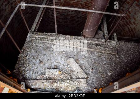 Rostiger Wasserturm von oben nach unten von innen. Alte Wasserpumpe. Leiter zum Wassertank, Taubenkot. Stockfoto