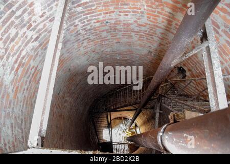 Rostiger Wasserturm von oben nach unten von innen. Alte Wasserpumpe. Leiter zum Wassertank, Taubenkot. Stockfoto