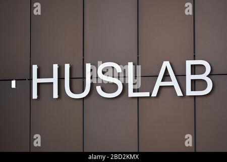 Helsinki, Finnland - 4. April 2020: Logo und Schild des HUSLAB-Labors an der Wand des Haupteingangs. Stockfoto