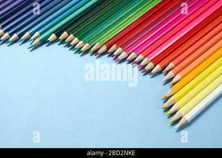 Auswahl an farbigen Bleistiften auf blauem Hintergrund.Schulausrüstung Stockfoto