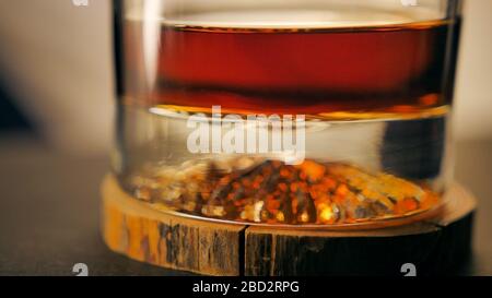 Ein Glas Luxus-Rum auf einer Holzuntersetzer Stockfoto