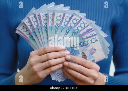 Eine Menge Kazakhstan Geld in einer Frau Hand. Weißer Hintergrund. Stockfoto