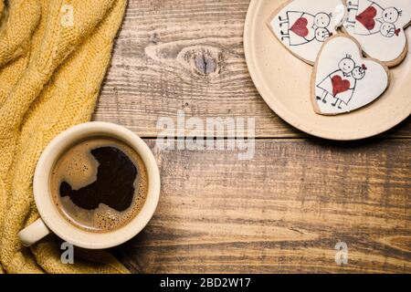 Tasse Kaffee und herzförmige Plätzchen auf rustikalem Holzhintergrund. Draufsicht mit Kopierbereich. Stockfoto