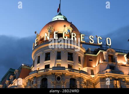 Nizza, Frankreich - Januar 2018: Nahaufnahme der Ecke des Negresco Hotels in Nizza, das in der Abenddämmerung beleuchtet wird Stockfoto