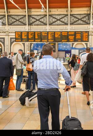 LONDON, ENGLAND - JULI 2018: Mann in den Ärmeln mit Koffer auf dem Golfplatz am Bahnhof London Paddington Stockfoto