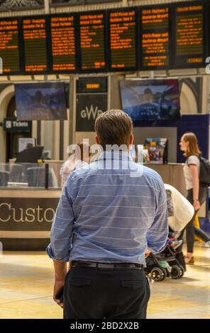 LONDON, ENGLAND - JULI 2018: Mann in den Schalenhülsen auf dem Golfplatz am Bahnhof London Paddington, der die Abfahrt des Zuges beobachtet Stockfoto