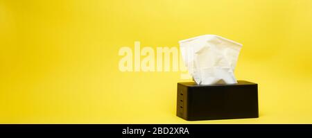 Weitschuss aus schwarzem Serviehalter auf minimalistischem gelbem Hintergrund Stockfoto