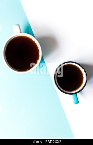 Flatlay Draufsicht von zwei Kaffeetassen auf weißem und blauem Papierhintergrund. Selektiver Fokus. Stockfoto