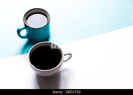 Flatlay Draufsicht von zwei Kaffeetassen auf weißem und blauem Papierhintergrund. Selektiver Fokus. Stockfoto