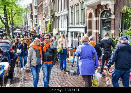 Amsterdam, Niederlande - 27. April 2019: Menschen auf der Straße, die orangefarbene Accessoires tragen, die den Kings Day, Koningsdag, den Geburtstag des niederländischen Königs Willem-Alexander feiern. Überfüllte Straßen. Stockfoto