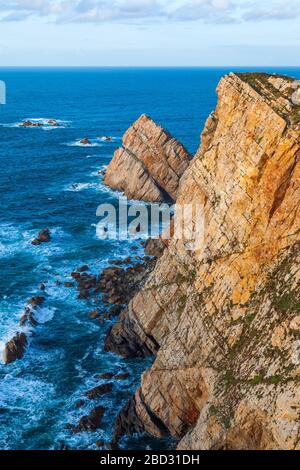Weitwinkelansicht der Klippen von Cabo de Peñas an einem bewölkten Tag. Asturien, Spanien. Stockfoto