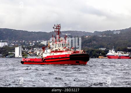 Schleppboot BB Coaster, das zum Hafen zurückkehrt, nachdem es einem Kreuzfahrtschiff geholfen hat, vom Hafen von Bergen, Norwegen abzufahren. Ein regnerischer und nebeliger Tag Stockfoto