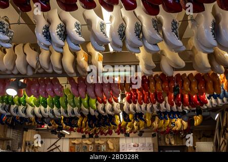 Traditionell farbenfroh bemalte holländische Clogs, die in einer Clogs-Werkstatt, Volendam, Nordholland, Niederlande, an der Decke hängen Stockfoto