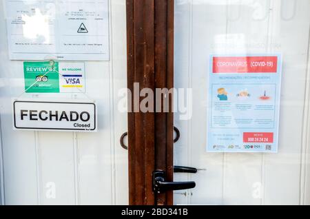 Faro, Portugal - 16. März 2020: Verschlossene Haustür des Restaurants mit einer Broschüre mit Sicherheitsanweisungen zu Coronavirus in Portugiesisch und Englisch. Die Restaurants sind wegen COVID-19-Ausbruchs geschlossen. Stockfoto