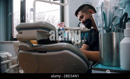 Ein Zahnarzt untersucht den Mund eines kleinen Jungen in der Zahnmedizin. Mittelaufnahme Stockfoto