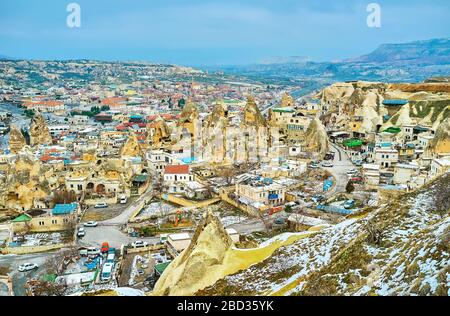 Die Klippen um Göreme überblicken die Stadt mit ihren kleinen Häusern, zahlreichen Hotels, Felsen und engen geschwungenen Straßen, Kappadokien, Türkei Stockfoto