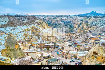 Der obere Blick auf die Altstadt, eingebettet zwischen den Klippen von Kappadokien mit Silhouette der mittelalterlichen Uchisar-Felsenburg am Horizont, Göreme, C. Stockfoto