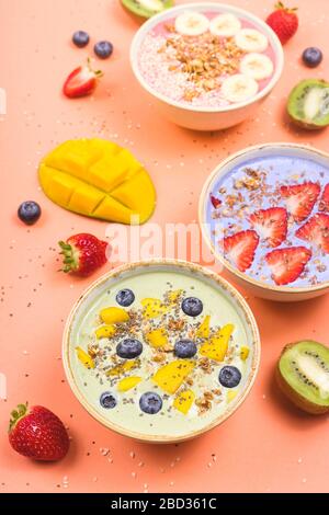 Schöne bunte, gesunde Smoothie-Schüsseln mit Beeren und Superfoods auf hellem Hintergrund. Sommeressen für das Entgiftungskonzept. Stockfoto